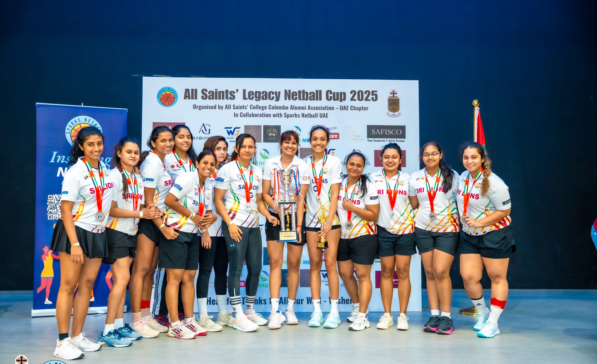 Team with medals and trophy on stage at last year's Legacy Netball Cup